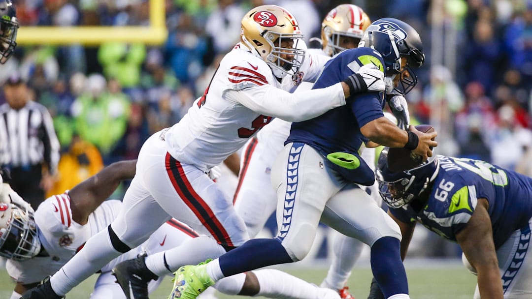 Dec 5, 2021; Seattle, Washington, USA; San Francisco 49ers defensive end Alex Barrett (94) sacks Seattle Seahawks quarterback Russell Wilson (3) during the fourth quarter at Lumen Field. Mandatory Credit: Joe Nicholson-Imagn Images