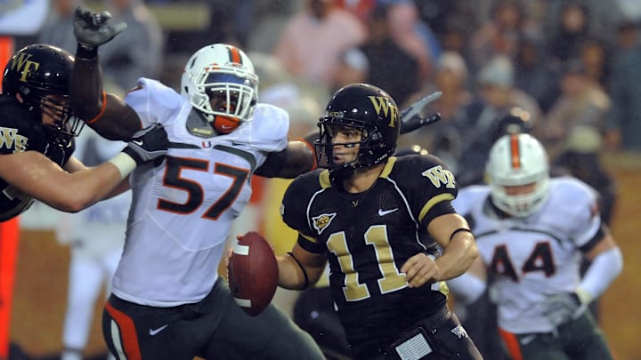 October 31, 2009; Winston-Salem, NC, USA; Wake Forest Demon Deacons quarterback Riley Skinner (11) is chased out of the pocket by Miami Hurricanes defensive lineman Allen Bailey (57) in the second half at BB&T Field. Miami defeated Wake Forest 28-27. Mandatory Credit: Dale Zanine-Imagn Images