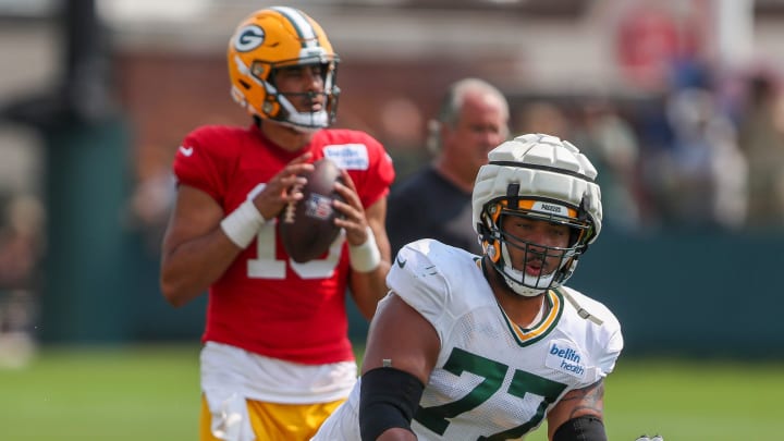 Green Bay Packers offensive lineman Jordan Morgan (77) runs through a drill during the seventh practice of training camp on Tuesday, July 30, 2024, at Ray Nitschke Field in Ashwaubenon, Wis.