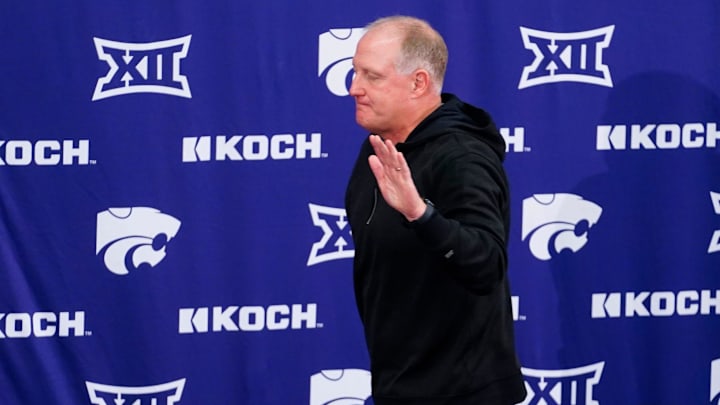 Kansas State football head coach Chris Klieman waves his hand after standing up at a press announcement where he shared his thoughts on his retirement inside the Vanier Football Complex on Dec. 3, 2025.