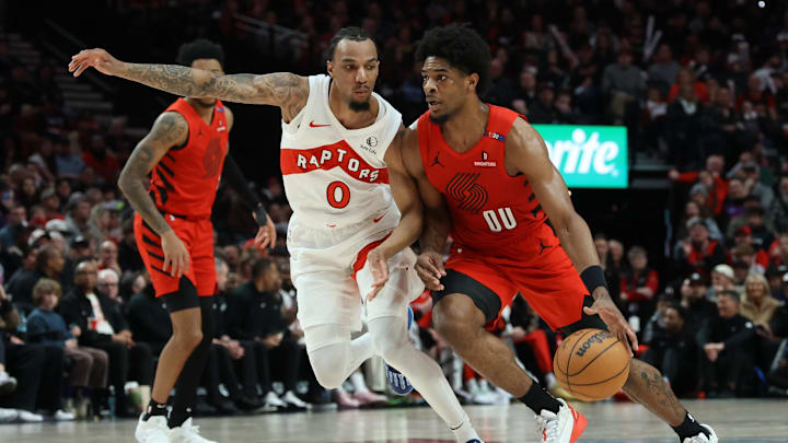 Mar 16, 2025; Portland, Oregon, USA;  Portland Trail Blazers guard Scoot Henderson (00) dribbles the ball past Toronto Raptors guard A.J. Lawson (0) in the second half at Moda Center. Mandatory Credit: Jaime Valdez-Imagn Images