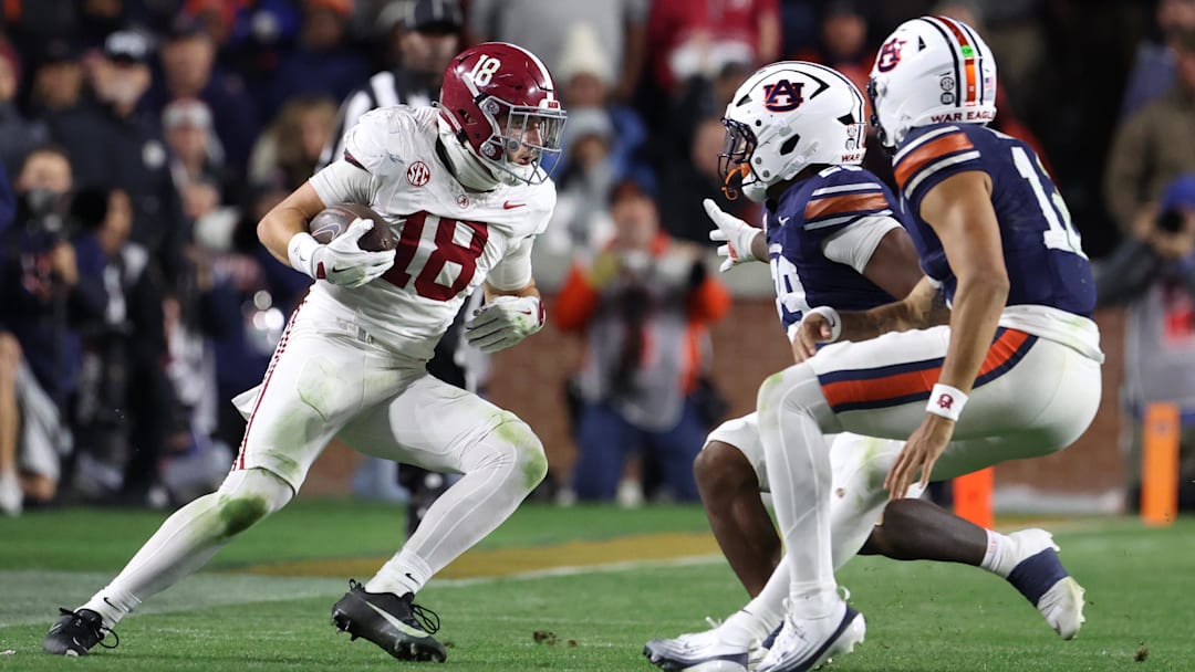 Nov 29, 2025; Auburn, Alabama, USA; Alabama Crimson Tide defensive back Bray Hubbard (18) intercepts the ball against Auburn Tigers running back Omar Mabson II (29) and quarterback Ashton Daniels (12) during the second half at Jordan-Hare Stadium. Mandatory Credit: John Reed-Imagn Images