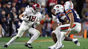 Nov 29, 2025; Auburn, Alabama, USA; Alabama Crimson Tide defensive back Bray Hubbard (18) intercepts the ball against Auburn Tigers running back Omar Mabson II (29) and quarterback Ashton Daniels (12) during the second half at Jordan-Hare Stadium. Mandatory Credit: John Reed-Imagn Images