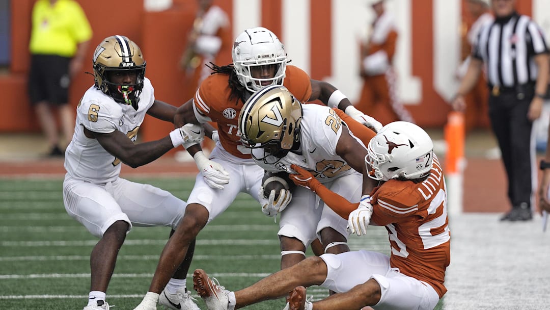 Nov 1, 2025; Austin, Texas, USA; Texas Longhorns defensive backs Graceson Littleton (29) and Jaylon Guilbeau (3) tackle Vanderbilt Commodores running back Makhilyn Young (22) during the first half  at Darrell K Royal-Texas Memorial Stadium. Mandatory Credit: Scott Wachter-Imagn Images