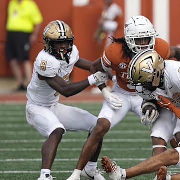 Nov 1, 2025; Austin, Texas, USA; Texas Longhorns defensive backs Graceson Littleton (29) and Jaylon Guilbeau (3) tackle Vanderbilt Commodores running back Makhilyn Young (22) during the first half  at Darrell K Royal-Texas Memorial Stadium. Mandatory Credit: Scott Wachter-Imagn Images