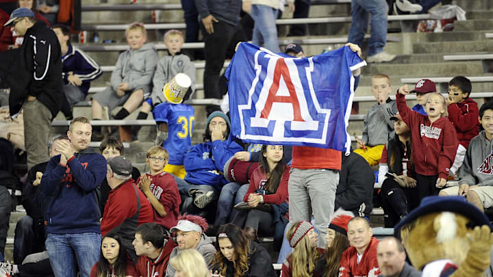 Oct 25, 2014; Pullman, WA, USA; Arizona Wildcats fans holds up the school flag during game against the Washington State Cougars during the second half at Martin Stadium. The Wildcats beat Cougars 59-37. Mandatory Credit: James Snook-Imagn Images