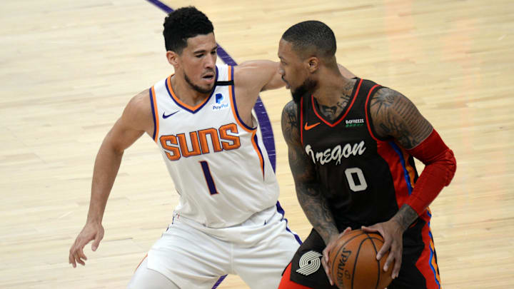 Phoenix Suns guard Devin Booker guards Portland Trail Blazers guard Damian Lillard. Phoenix Suns guard Devin Booker guards Portland Trail Blazers guard Damian Lillard.