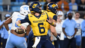 Dec 27, 2023; Charlotte, NC, USA; West Virginia Mountaineers quarterback Garrett Greene (6) throws a touchdown pass on the first play of the game in the first half at Bank of America Stadium. Mandatory Credit: Bob Donnan-USA TODAY Sports