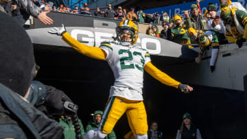 Green Bay Packers cornerback Jaire Alexander high fives a fan while taking to the field before their