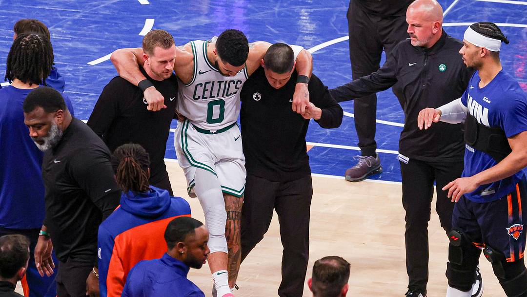 May 12, 2025; New York, New York, USA; Boston Celtics forward Jayson Tatum (0) is helped off the court by after an injury in the second half during game four of the second round for the 2025 NBA Playoffs against the New York Knicks at Madison Square Garden. Tatum would leave the game with an injury after this play. Mandatory Credit: Vincent Carchietta-Imagn Images