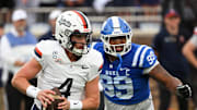 Nov 15, 2025; Durham, North Carolina, USA;  Virginia Cavaliers quarter back Chandler Morris (4) looks for an opening against Duke Blue Devils defensive tackle Aaron Hall (99) during the first quarter at Wallace Wade Stadium. Mandatory Credit: Zachary Taft-Imagn Images