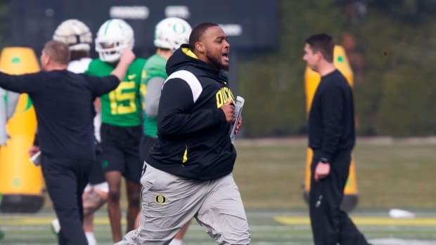 New offensive line coach A'lique Terry runs between drills during the first practice of spring for Oregon football