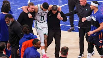 May 12, 2025; New York, New York, USA; Boston Celtics forward Jayson Tatum (0) is helped off the court by after an injury in the second half during game four of the second round for the 2025 NBA Playoffs against the New York Knicks at Madison Square Garden. Tatum would leave the game with an injury after this play. Mandatory Credit: Vincent Carchietta-Imagn Images
