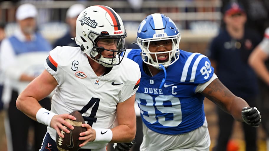 Virginia Cavaliers quarterback Chandler Morris with the ball as a Duke defender rushes him.