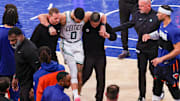 May 12, 2025; New York, New York, USA: Boston Celtics forward Jayson Tatum (0) is helped off the court by after an injury in the second half during game four of the second round for the 2025 NBA Playoffs against the New York Knicks at Madison Square Garden. Tatum would leave the game with an injury after this play. Mandatory Credit: Vincent Carchietta-Imagn Images