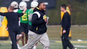 New offensive line coach A'lique Terry runs between drills during the first practice of spring for Oregon football Thursday March 16, 2023