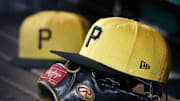 Pittsburgh Pirates hats and gloves in the dugout against the New York Yankees during the sixth inning at PNC Park in 2023.