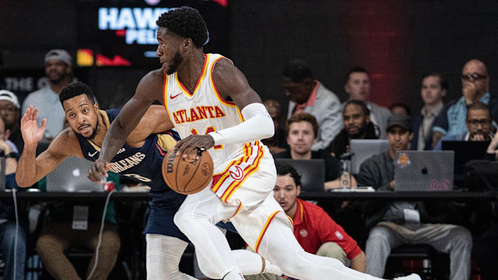 Oct 14, 2023; College Park, Georgia, USA; Atlanta Hawks forward AJ Griffin (14) drives the ball against New Orleans Pelicans guard CJ McCollum (3) during the third quarter at Gateway Center Arena at College Park. Mandatory Credit: Jordan Godfree-Imagn Images