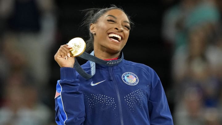 Aug 3, 2024; Paris, France; Simone Biles of the United States celebrates her gold medal during the medal ceremony for the vault on the first day of gymnastics event finals during the Paris 2024 Olympic Summer Games at Bercy Arena. 