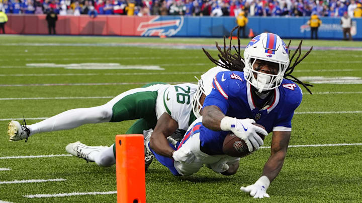 Buffalo Bills running back James Cook reaches for the end zone as he is tackled by New York Jets cornerback Brandin Echols.