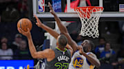 Mar 24, 2024; Minneapolis, Minnesota, USA; Minnesota Timberwolves center Rudy Gobert (27) shoots against the Golden State Warriors forward Draymond Green (23) in the third quarter at Target Center. Mandatory Credit: Brad Rempel-Imagn Images