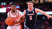 Mar 8, 2025; Syracuse, New York, USA; Syracuse Orange guard Kyle Cuffe Jr. (0) drives against Virginia Cavaliers guard Isaac McKneely (11) during the first half at the JMA Wireless Dome. Mandatory Credit: Rich Barnes-Imagn Images