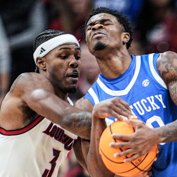 Louisville Cardinals guard Ryan Conwell (3) tussles with Kentucky Wildcats guard Otega Oweh (00) for control in the first half during the UofL-UK annual rivalry game at the KFC Yum! Center in Louisville, Kentucky Nov. 11, 2025.