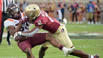 Oct 7, 2023; Tallahassee, Florida, USA; Florida State Seminoles defensive back Conrad Hussey (12) tackles Virginia Tech Hokies running back Bhayshul Tuten (33) during the second half against the at Doak S. Campbell Stadium. Mandatory Credit: Melina Myers-USA TODAY Sports