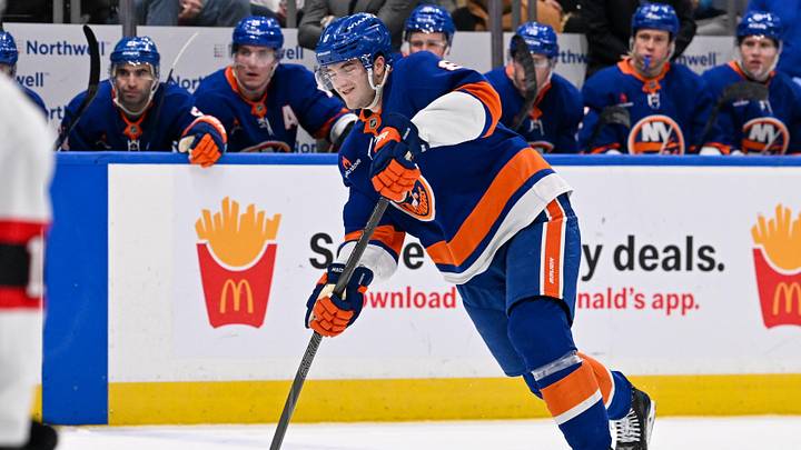 Jan 14, 2025; Elmont, New York, USA;  New York Islanders defenseman Noah Dobson (8) attempts a shot against the Ottawa Senators during the second period at UBS Arena. Mandatory Credit: Dennis Schneidler-Imagn Images