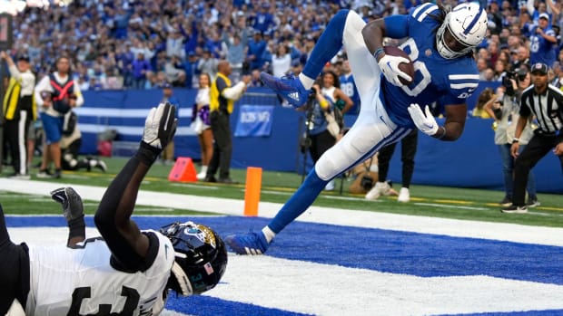 Colts tight end Jelani Woods (blue jersey with white pants/helmet) catches a touchdown in a blue and white endzone. 