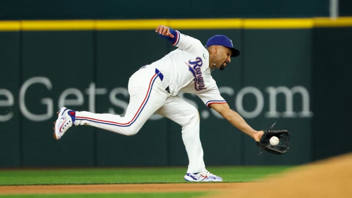 Aug 20, 2024; Arlington, Texas, USA; Texas Rangers second baseman Marcus Semien (2) fields a ground ball during the eighth inning against the Pittsburgh Pirates  at Globe Life Field. 