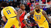 Feb 4, 2025; Inglewood, California, USA; Los Angeles Lakers forward LeBron James (23) moves the ball as center Jaxson Hayes (11) provides coverage against Los Angeles Clippers guard Kris Dunn (8) during the second half at Intuit Dome. Mandatory Credit: Gary A. Vasquez-Imagn Images