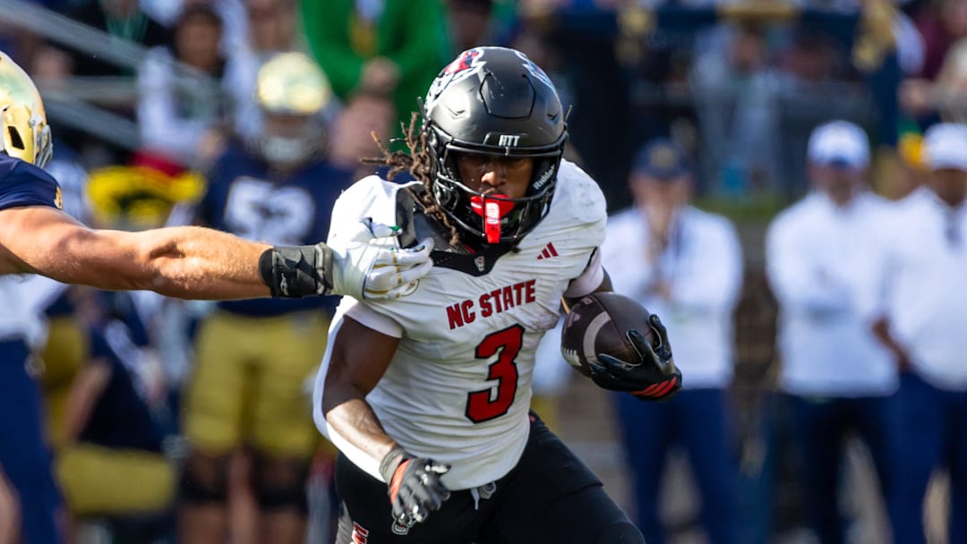 Oct 11, 2025; South Bend, Indiana, USA; NC State Wolfpack running back Hollywood Smothers (3) tries to break a tackle attempt by Notre Dame Fighting Irish linebacker Joshua Burnham (40) during the first half at Notre Dame Stadium. Mandatory Credit: Michael Caterina-Imagn Images