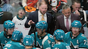 Oct 11, 2025; San Jose, California, USA; San Jose Sharks head coach Ryan Warsofsky (center) talks with players during the third period against the Anaheim Ducks at SAP Center at San Jose. Mandatory Credit: Darren Yamashita-Imagn Images