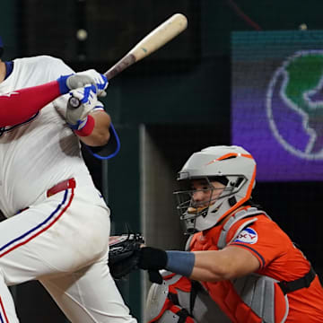 May 15, 2025; Arlington, Texas, USA; Texas Rangers first baseman Jake Burger (21) hits a single during the eighth inning against the Houston Astros at Globe Life Field. 