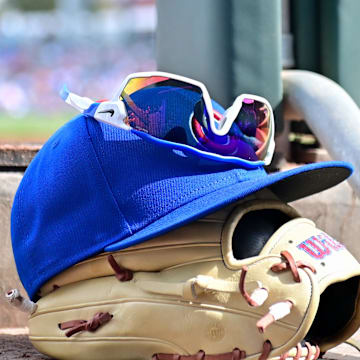 Feb 27, 2024; Mesa, Arizona, USA;  General view of a Chicago Cubs glove, hat and glasses in the first inning against the Cincinnati Reds during a spring training game at Sloan Park. Mandatory Credit: Matt Kartozian-Imagn Images