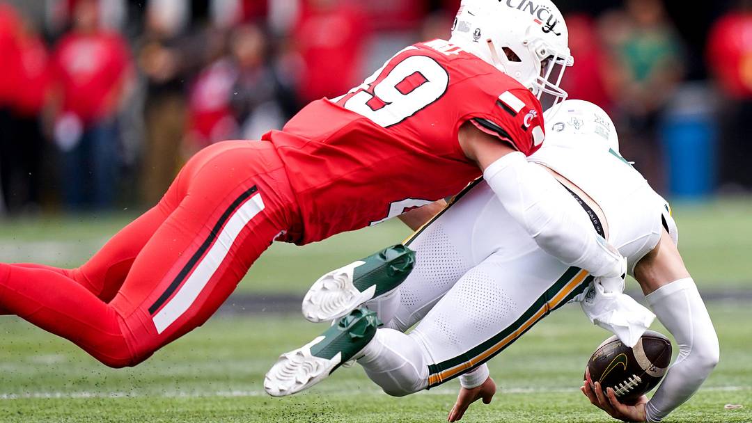 Cincinnati Bearcats linebacker Jack Dingle (49) tackles Baylor Bears quarterback Sawyer Robertson (13) in the first quarter of a NCAA men’s football game between the Cincinnati Bearcats and Baylor Bears, Saturday, Oct. 25, 2025, at Nippert Stadium in Cincinnati.
