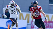 Northern Illinois Huskies quarterback Rocky Lombardi (12) carries for a first down against Arkansas State Red Wolves defensive end Thurman Geathers (92) in first half action in the Camellia Bowl at Cramton Bowl in Montgomery, Ala., on Saturday December 23, 2023.