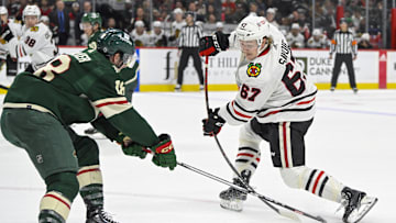 Sep 30, 2023; Saint Paul, Minnesota, USA; Minnesota Wild forward Sammy Walker (18) pokes the puck away from Chicago Blackhawks forward Samuel Savoie (67) during the second period at Xcel Energy Center. Mandatory Credit: Nick Wosika-Imagn Images

