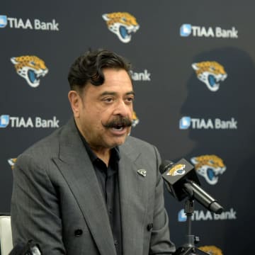 Jacksonville Jaguars owner Shad Khan takes questions from the media as his new first-round draft pick Trevor Lawrence looks on. After his arrival in Jacksonville, Florida Friday morning, April 30, 2021, Jacksonville Jaguars first-round draft pick Trevor Lawrence along with team owner Shad Khan, head coach Urban Meyer and the Jaguars general manager Trent Baalke held a press conference in the afternoon inside TIAA Bank Field. They were also joined by the Jaguars' 25th pick in the first round of