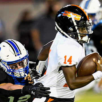 Hoover's Jonah Winston (14) tries to shake the tackle of Auburn High School's Coleman Granberry (12) during their game at Cramton Bowl in Montgomery, Ala., on Friday evening August 19, 2022.