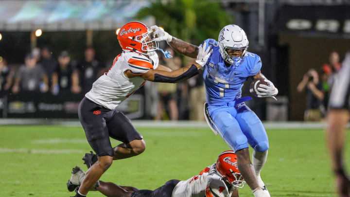 Nov 11, 2023; Orlando, Florida, USA; UCF Knights running back RJ Harvey (7) is pushed out of bounds by Oklahoma State Cowboys safety Cameron Epps (7) during the second half at FBC Mortgage Stadium. Mandatory Credit: Mike Watters-USA TODAY Sports