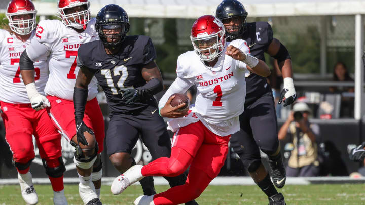 Nov 25, 2023; Orlando, Florida, USA; Houston Cougars quarterback Donovan Smith (1) runs the ball in front of UCF Knights defensive end Shaun Peterson Jr. (12) during the second quarter at FBC Mortgage Stadium.  