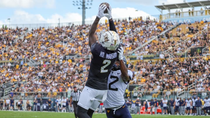 Oct 28, 2023; Orlando, Florida, USA; UCF Knights wide receiver Kobe Hudson (2) catches a pass in front of West Virginia Mountaineers safety Anthony Wilson (12) and scores during the first quarter at FBC Mortgage Stadium. Mandatory Credit: Mike Watters-USA TODAY Sports