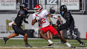 Nov 25, 2023; Orlando, Florida, USA; Houston Cougars wide receiver Stephon Johnson (12) runs the ball as UCF Knights linebacker Kam Moore (30) and defensive back Quadric Bullard (10) during the second half at FBC Mortgage Stadium. Mandatory Credit: Mike Watters-Imagn Images