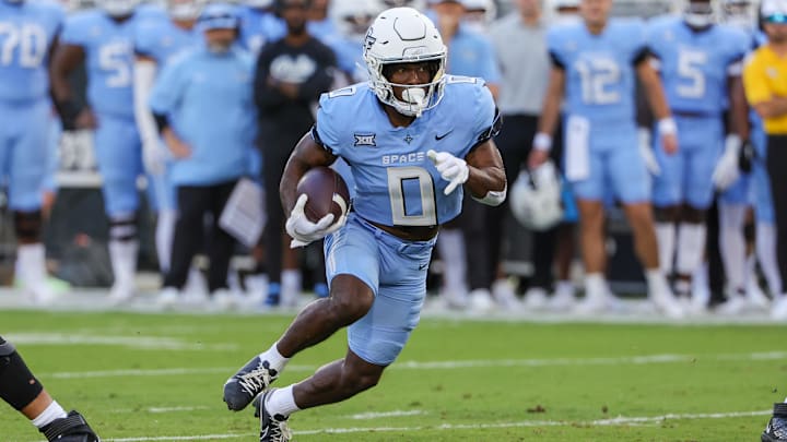 Nov 11, 2023; Orlando, Florida, USA; UCF Knights running back Johnny Richardson (0) runs the ball during the first quarter against the Oklahoma State Cowboys at FBC Mortgage Stadium. Mandatory Credit: Mike Watters-Imagn Images