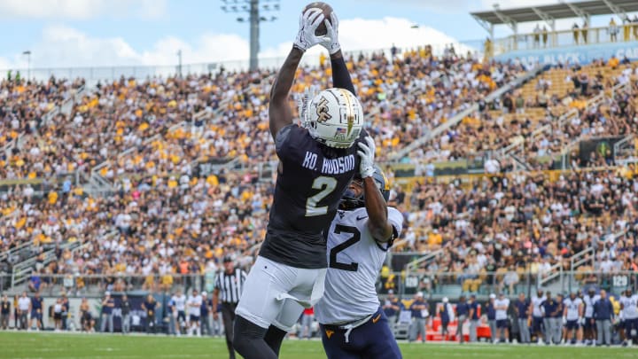 Oct 28, 2023; Orlando, Florida, USA; UCF Knights wide receiver Kobe Hudson (2) catches a pass in front of West Virginia Mountaineers safety Anthony Wilson (12) and scores during the first quarter at FBC Mortgage Stadium. Mandatory Credit: Mike Watters-USA TODAY Sports