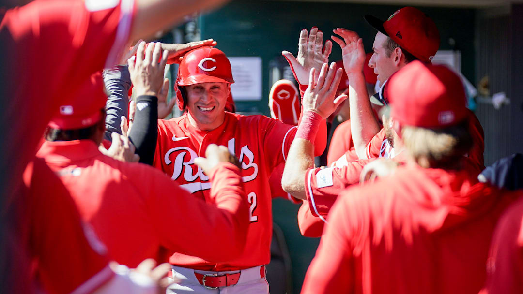 Cincinnati Reds right fielder JJ Bleday (22) is embraced by teammates in the dugout after hitting a homer in the third inning of a Cactus League game between the Cincinnati Reds and Chicago White Sox, Wednesday, Feb. 25, 2026.