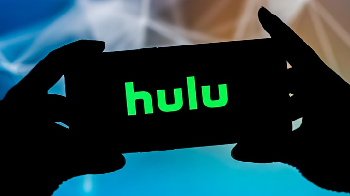 In this photo illustration, a Hulu logo seen displayed on a...