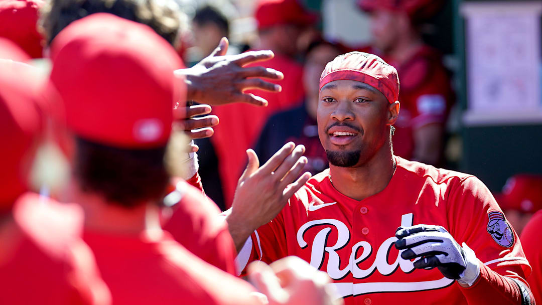 Cincinnati Reds left fielder Will Benson (30) is embraced by teammates in the dugout after hitting a homer in the third inning of a Cactus League game between the Cincinnati Reds and Cleveland Guardians, Saturday, Feb. 21, 2026, at Goodyear Ballpark in Goodyear, Ariz.